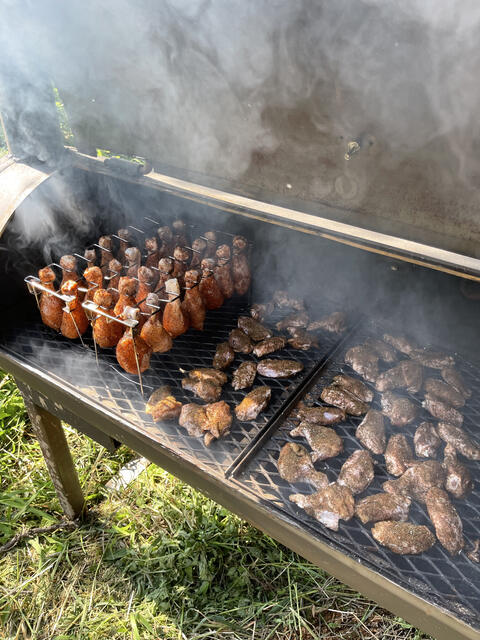 The offset smoker loaded with racks, smoke rolling
