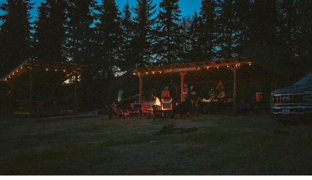 The gazebo glowing under string lights at night