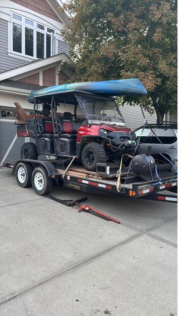 A loaded trailer in a suburban driveway, ready to head north